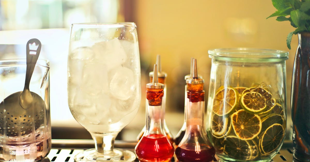 What happens when you mix whiskey and water? - Glass of ice cubes on counter with ingredients