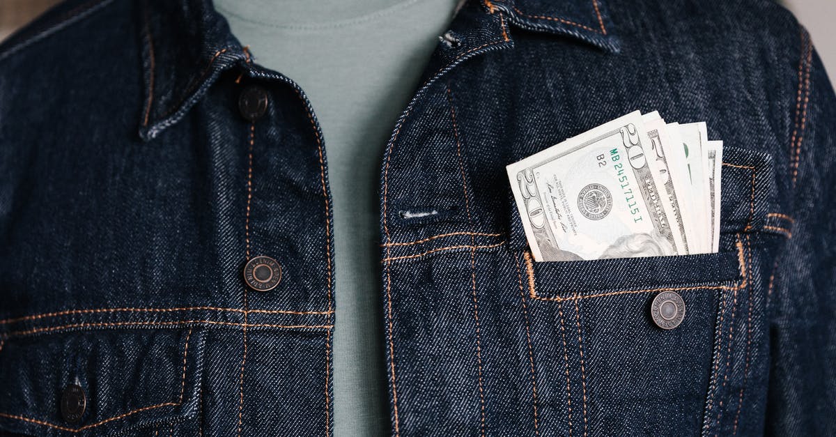 What international cooking terms sound similar but have different meanings? - Crop unrecognizable male in casual outfit standing with different nominal pars of dollar banknotes in pocket of jeans jacket