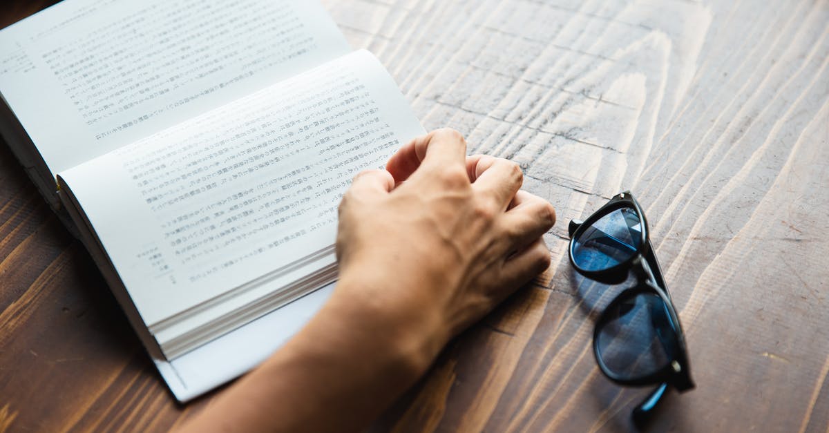 What is a good book about soup? - Crop faceless person sitting at table and reading book