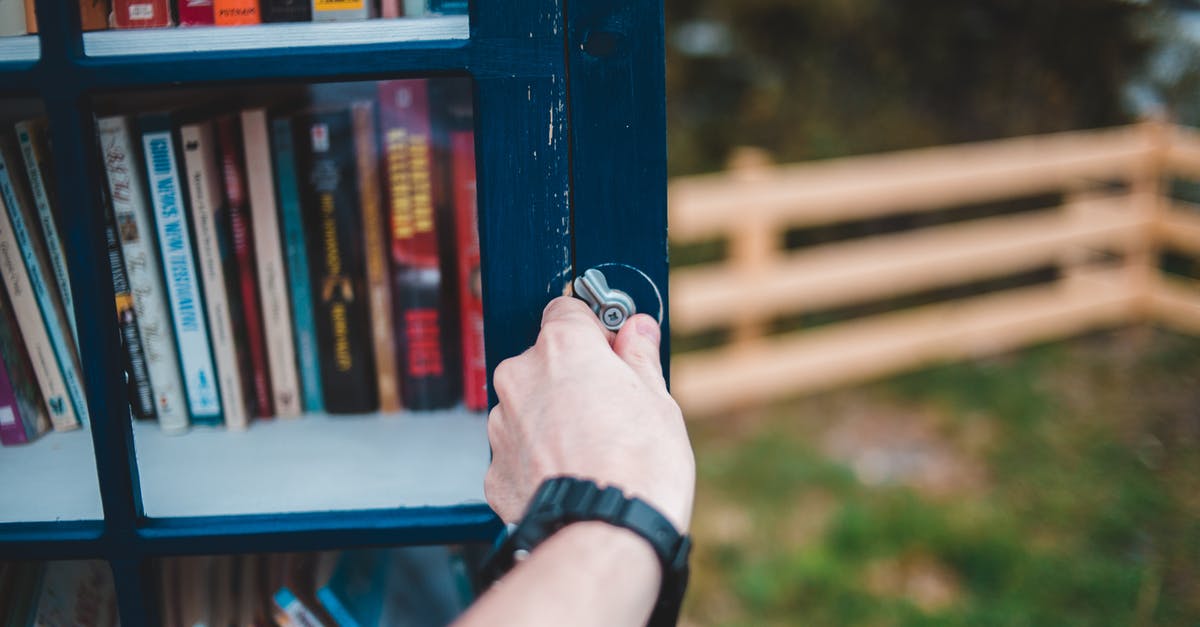 What is a good book about soup? - Crop person opening public bookcase in park