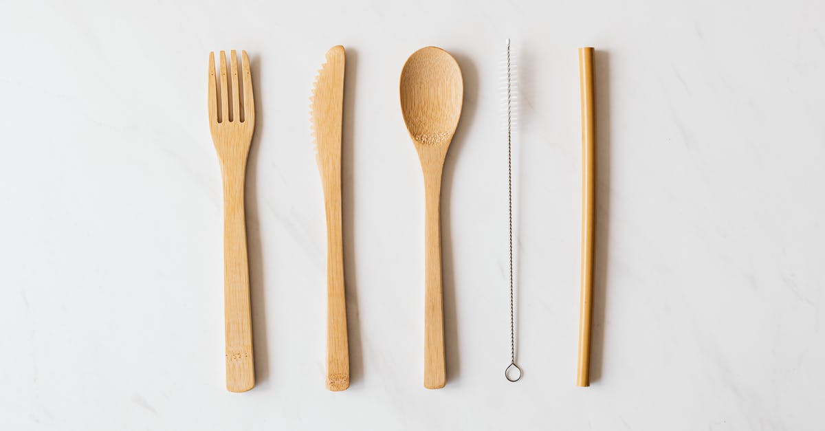 What is a Hostess Set of flatware? - Wooden cutlery and tube with brush on marble table