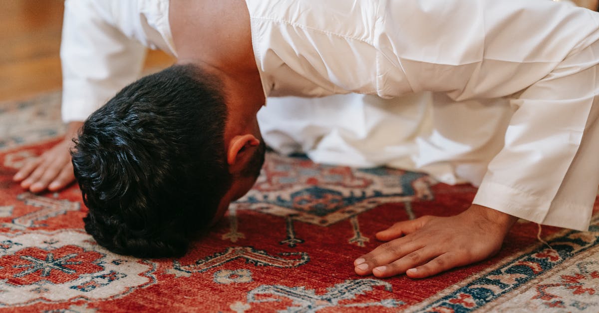 What is a spinach head is equal to? - Man in White Thobe Bowing Down on Red and Blue Rug