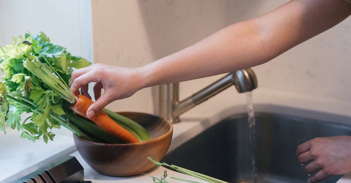 What is a substitute for celery root in a soup? - Person Holding Green Vegetable on Stainless Steel Sink