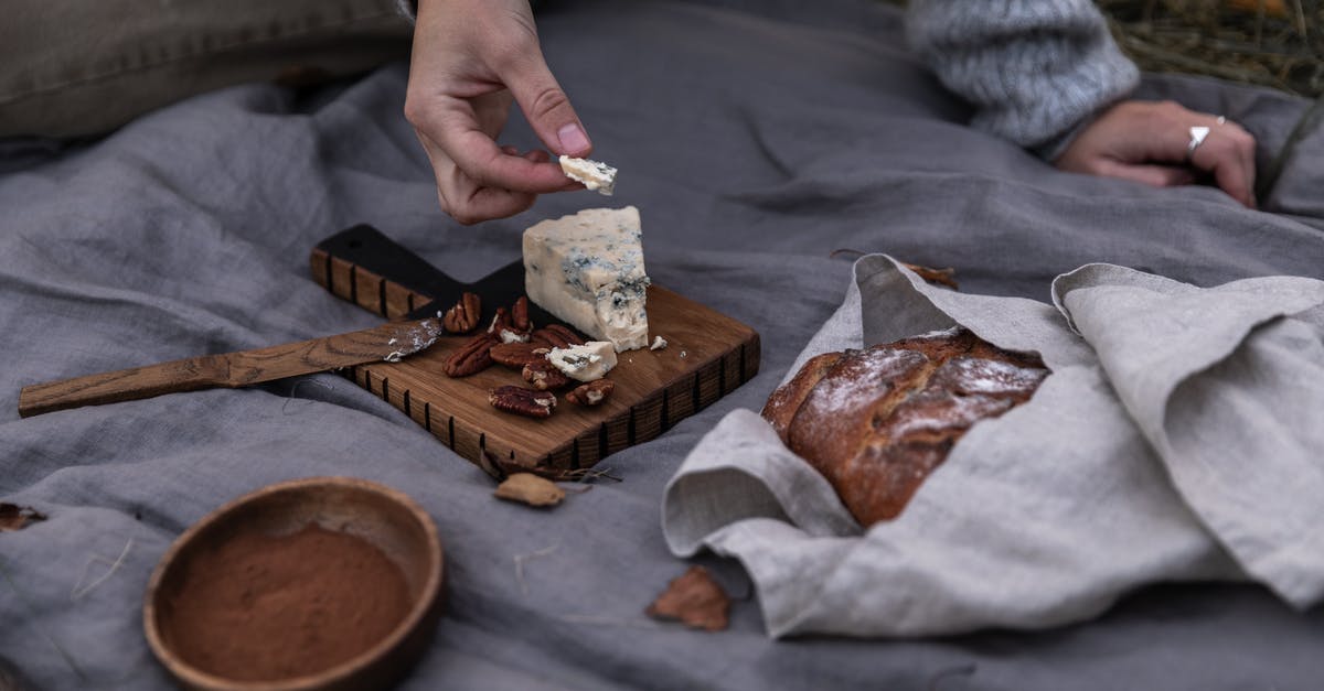 What is a substitute for mascarpone cheese? - Person Holding Brown Wooden Chopping Board