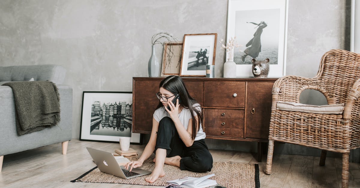 What is distilled or freeze-concentrated mead called? - Focused young woman with laptop and smartphone in modern apartment