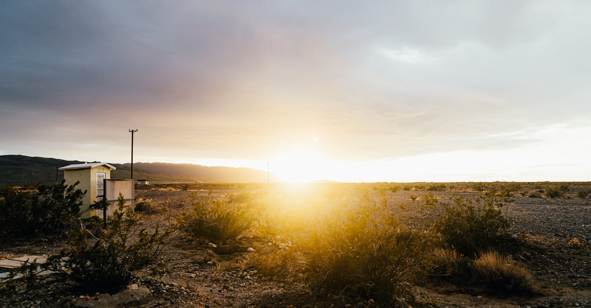 What is dry cottage cheese? - Bright sun shining over empty rural dirty field with small house during sunset on cloudy day