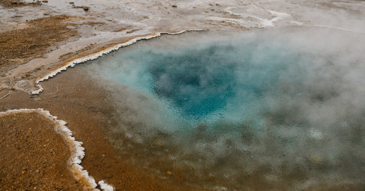 What is hot raspberry puree? - High angle picturesque scenery of hot geyser with crystal clear blue water on sandy terrain