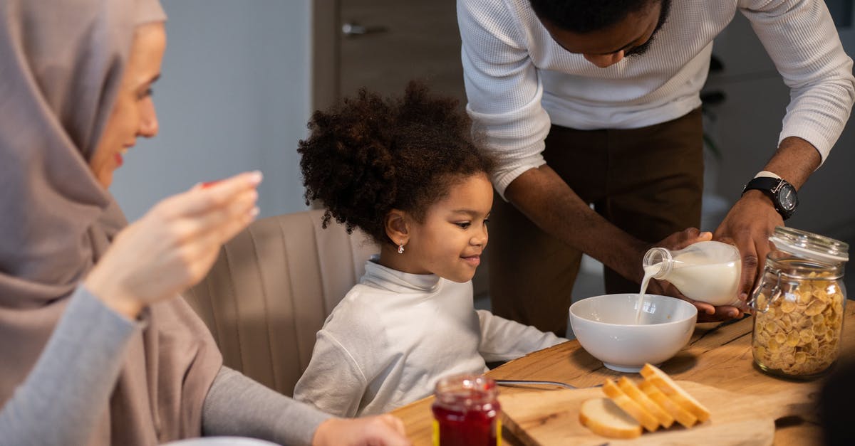 What is milk classified as once you pour it on cereal? - Cheerful diverse family having breakfast with milk and cereals