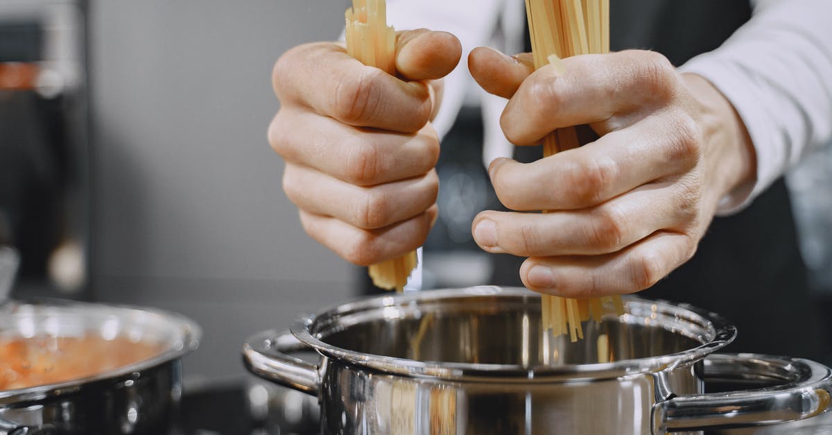 What is the benefit of a pasta pot with an inset? - Person putting Pasta on a Stainless Pot 