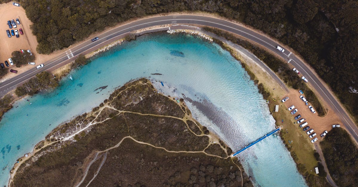 What is the best way to clean a grater? - Drone view of curvy asphalt road with many automobiles and narrow blue clean river