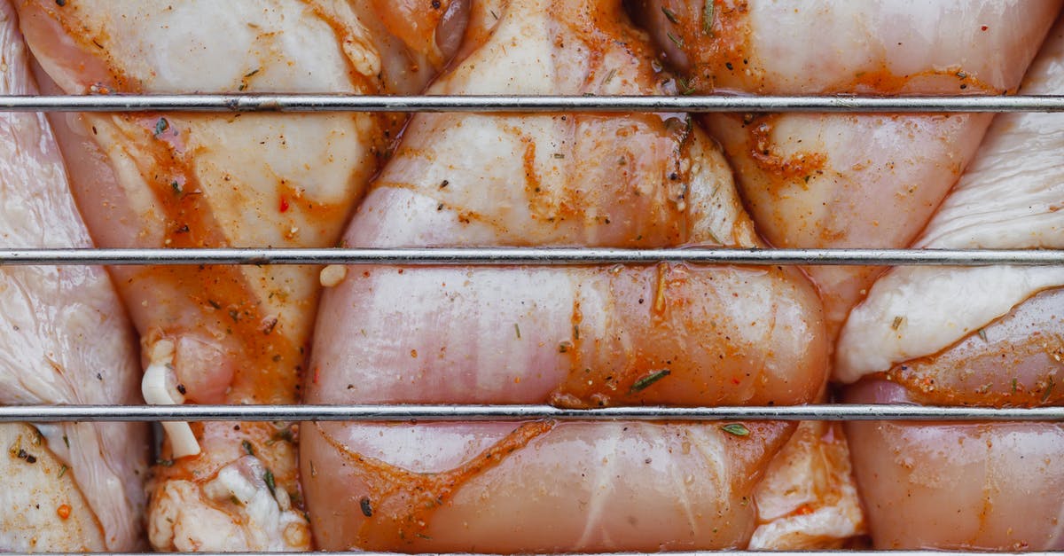 What is the correct order to both marinate and velvet the meat? - From above of closeup of raw chicken legs with seasoning cooking on metal grill grate