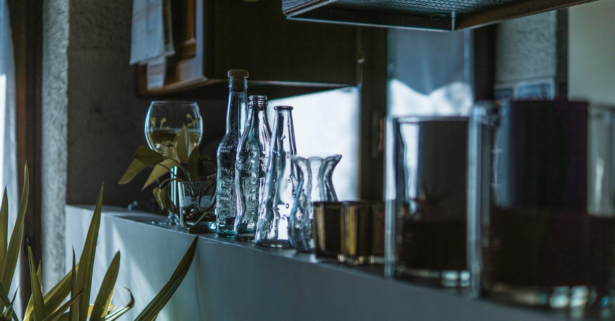 What is the dark stuff inside a green bell pepper? - Assorted Clear Glass Bottles With Wine Glass in the Shelf