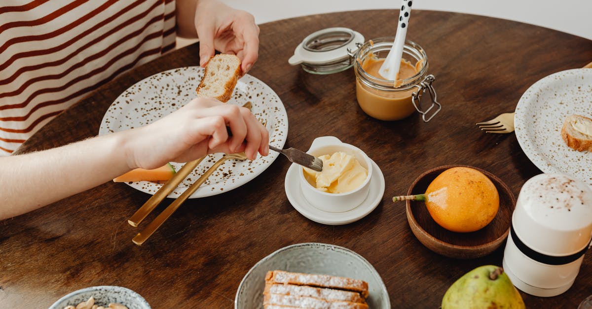 what is the difference between butter spread and pure butter? - A Person Holding a Toasted Bread