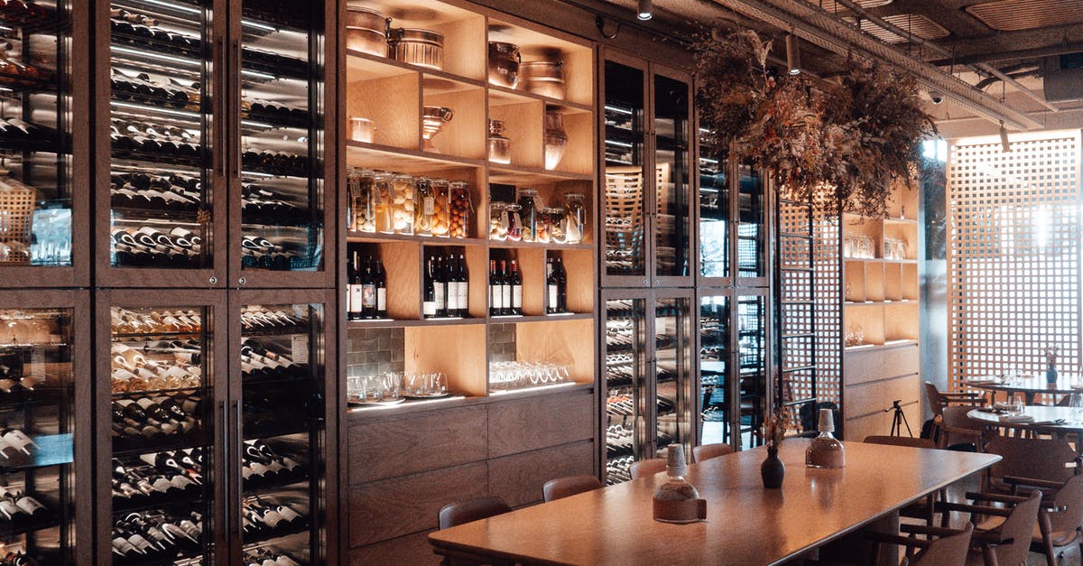 What is the difference between expensive wine and regular wine? - Wall with shelves with collection of assorted wine in modern restaurant with wooden furniture and creative decor