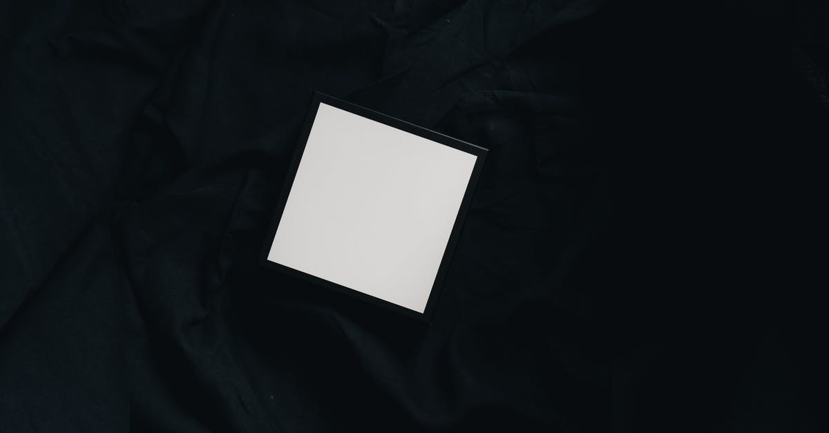 What is the difference between green, white and black tea? - Top view of small white square carton present box with smooth surface and dense texture on black background