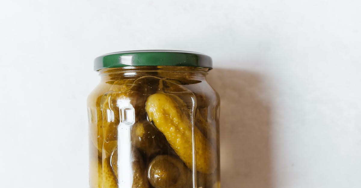What is the difference in flavor between a fermented pickle and a vinegar pickle? - Clear Glass Jar With Green and Yellow Fruits