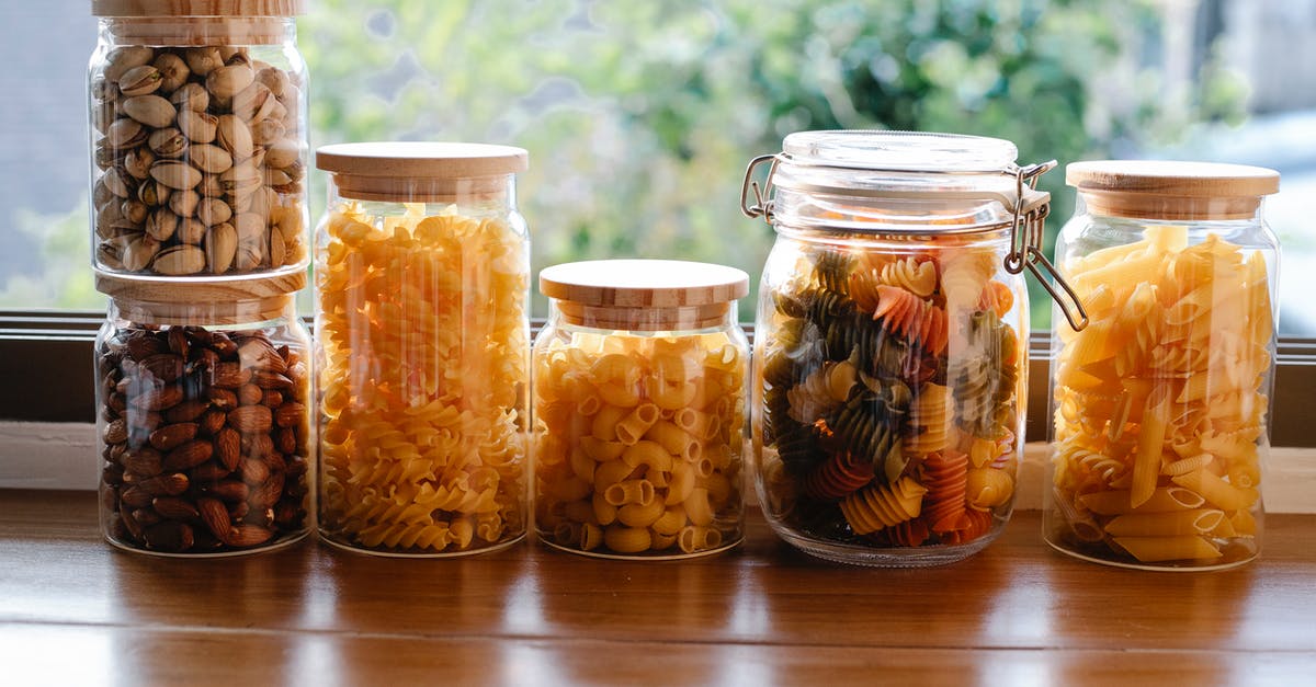 What is the difference in method between French and Italian macarons? - Glass jars filled with assorted types of uncooked pasta and pistachios with almonds placed on wooden table near window in light room