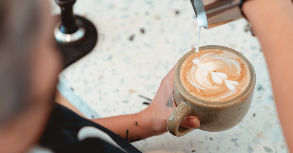 What is the foam that comes out when making clarified butter? - Photo of Barista Pouring Milk on Latte