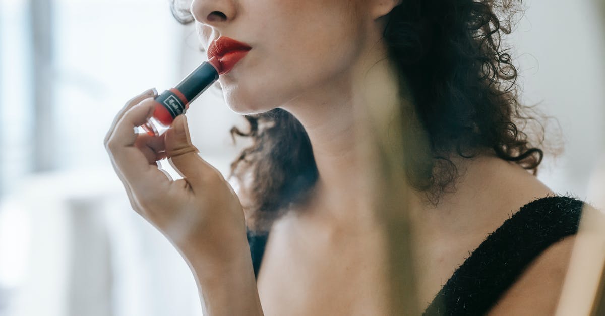 What is the functional purpose of straining out shallots from a Beurre Rouge (Red Butter Sauce)? - Content young woman applying red lipstick on lips