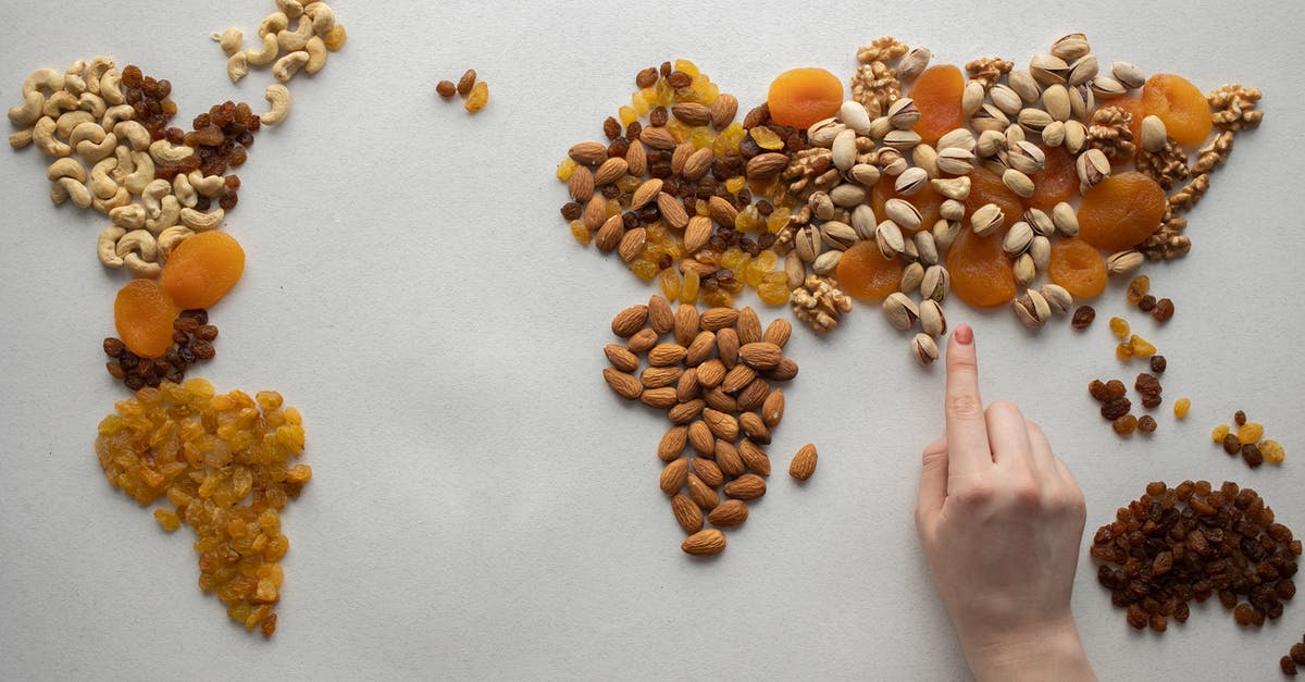 What is the inside of a nut called? - Faceless person making world map with nuts and dried fruits