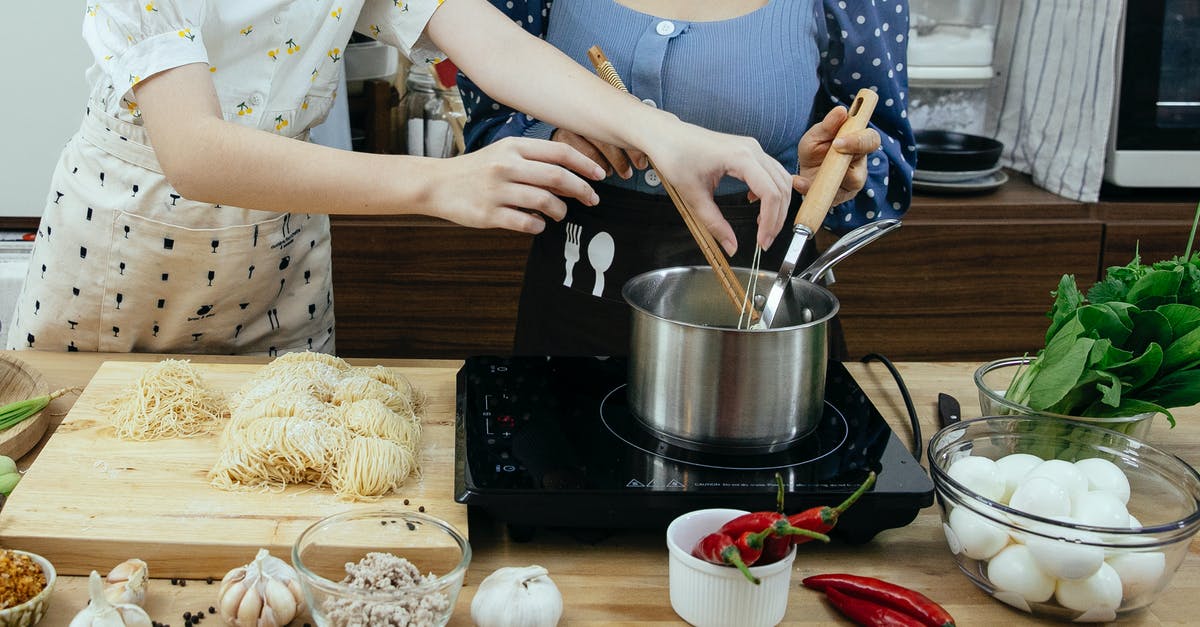 What is the modern alternative to sieving soup recipes? - Crop faceless women cooking traditional noodle dish together