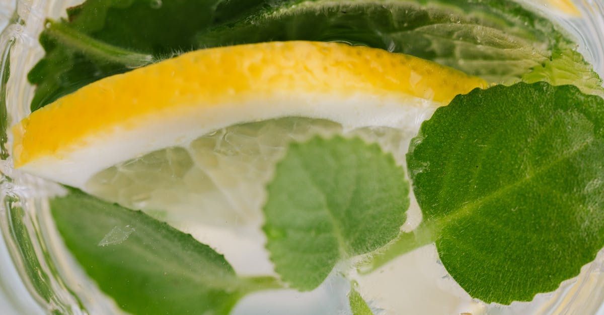 What is the most effective way to extract mint flavor for a Mojito? - Closeup top view of nonalcoholic drink made of slices of lemon and leaves of mint