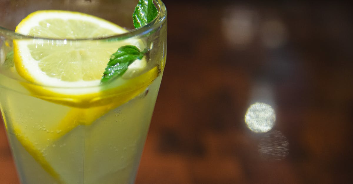 What is the most effective way to extract mint flavor for a Mojito? - Glass of cold sour lemonade served with lemon slices and fresh mint leaf on blurred wooden table