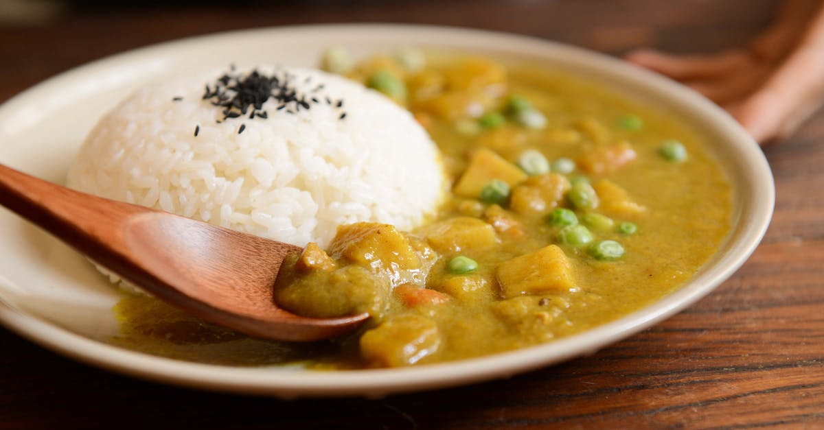 What is the name of this chicken soup dish? - Cooked Rice and Curry Food Served on White Plate