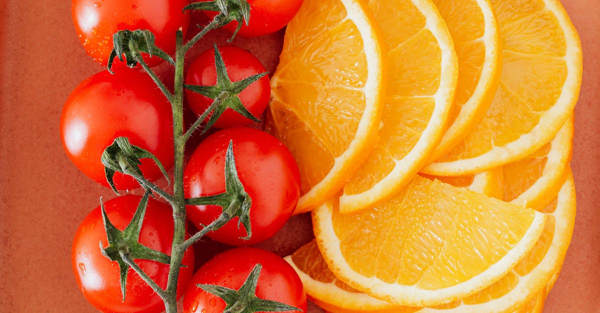 What is the orange part on a scallop? - Top view closeup of branch of ripe tomatoes with drops and slices of big cut lemons placed on table