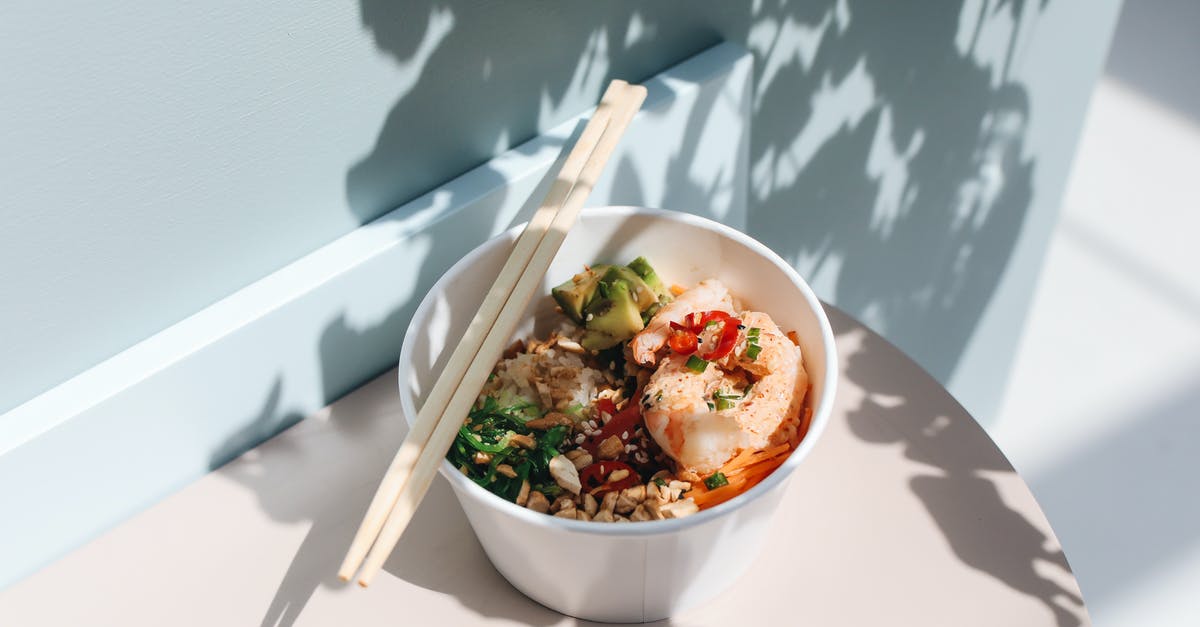 What is the origin of spam musubi, a Hawaiian dish? - Close-Up Photograph of Wooden Chopsticks on Top of a Poke Bowl