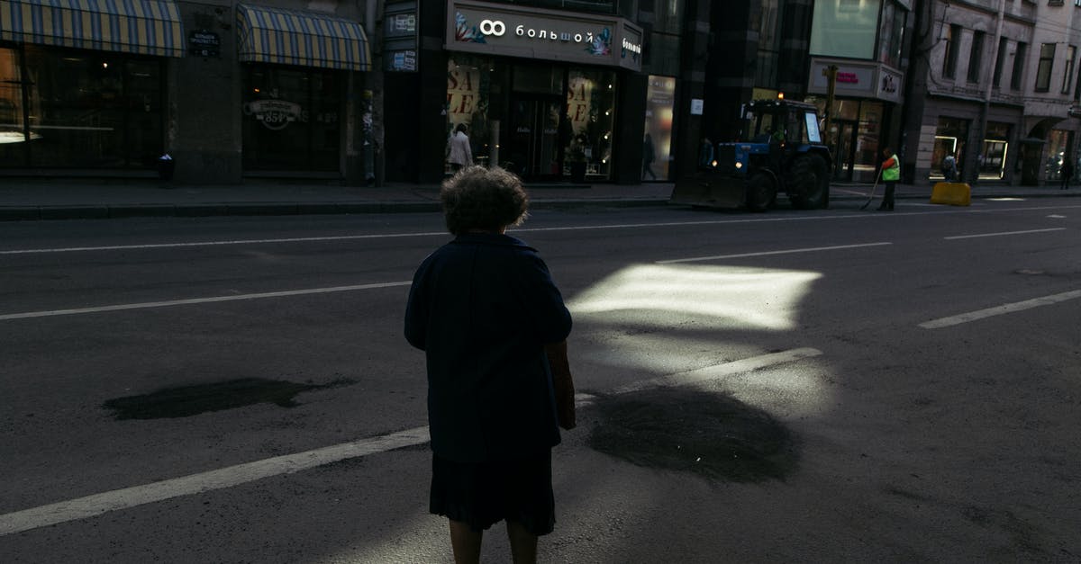 What is the proper way to brine fish? - Full body back view of anonymous male standing on empty asphalt roadway on street with showcases in buildings in city  with sunbeam