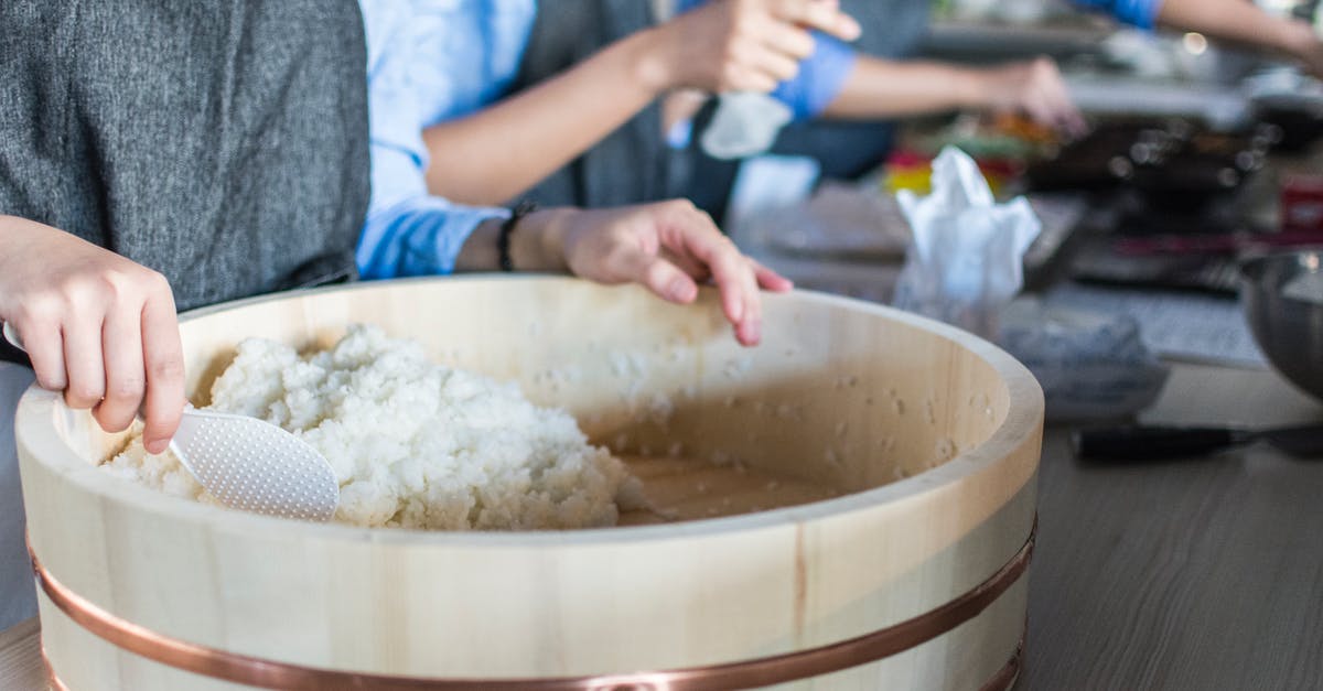 What is the proper way to cool sushi rice after cooking? - Person Holding White Plastic Ladle