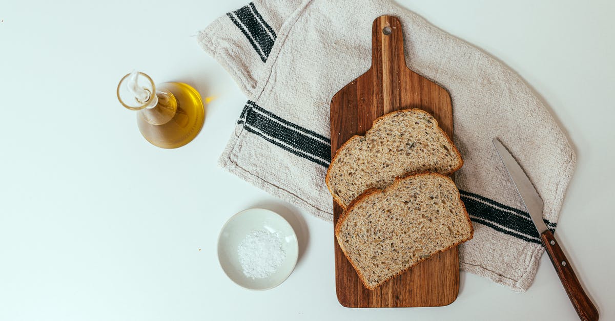 What is the purpose of oiling a wooden chopping board? - A Chopping Board on Towel with Slices of Bread Beside Olive Oil and Salt