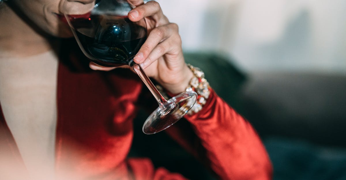 What is the purpose of red wine vinegar in steak marinades? - Crop unrecognizable female in bright red dress with jewelry drinking red wine on blurred background