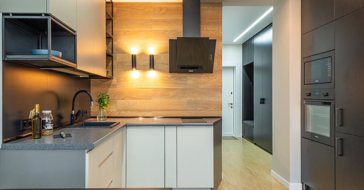 What is the purpose of the storage beneath an oven? - Interior of contemporary kitchen with counter under shelves and cabinets with microwave and oven with hood