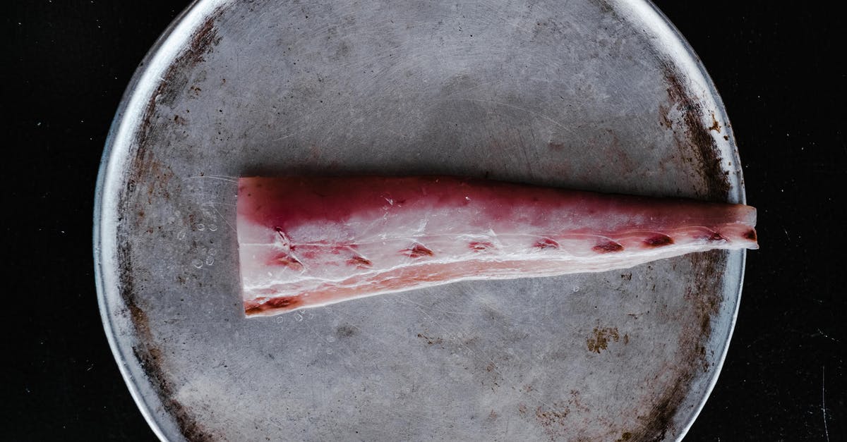 What is the purpose of wrapping fish with aluminum foil? - Raw Fish Meat on Round Steel Plate