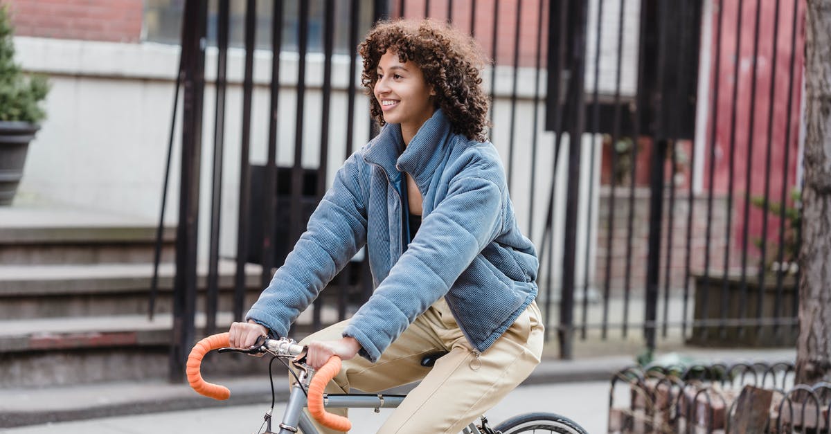 What is the rise / fall / feed cycle of a sourdough starter? - Happy ethnic young trendy female in blue jacket smiling while riding bicycle on city street in autumn