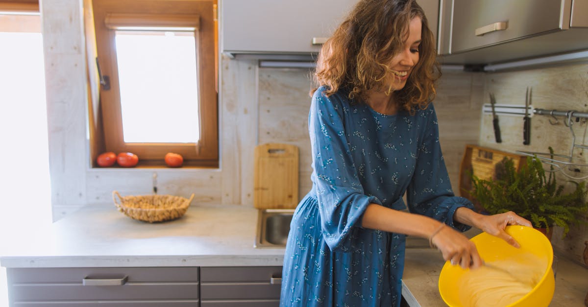 What is the rule of thumb for mixing doughs? - Woman in Blue Dress Holding Yellow Plastic Bowl