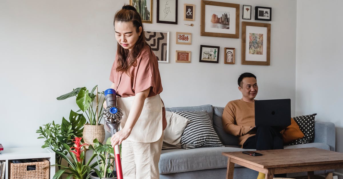 What is the technique for Vacuum Flask Cooking? - Woman in White Dress Standing Beside Woman in Gray Dress Sitting on Couch