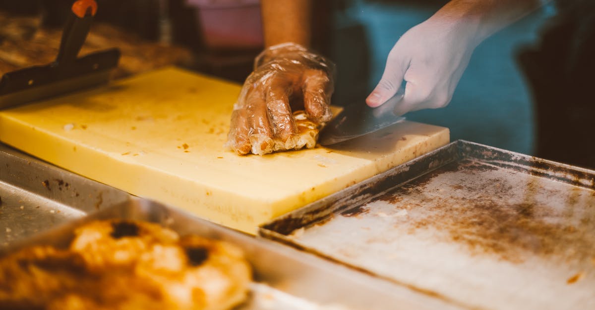 What is this double-serrated knife good for? - Person Slicing Bread on Chopping Board