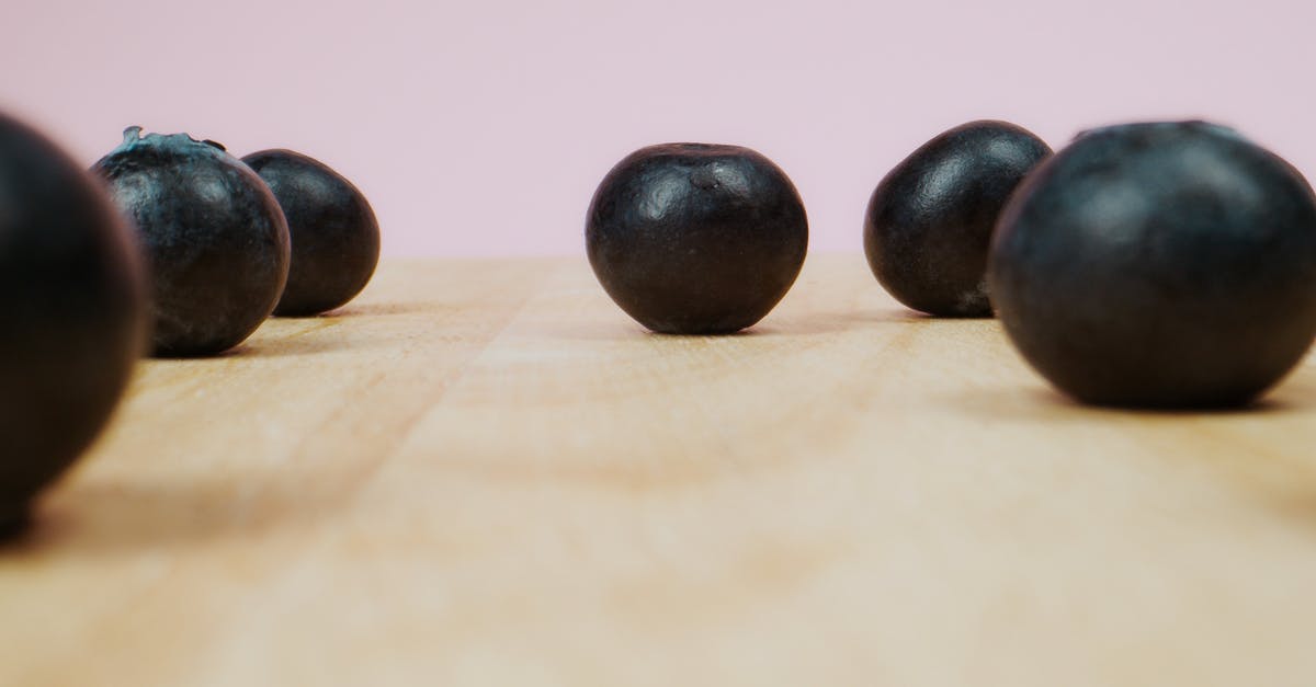 What is this fruit, anyone knows? - Black Round Fruit on Brown Wooden Table