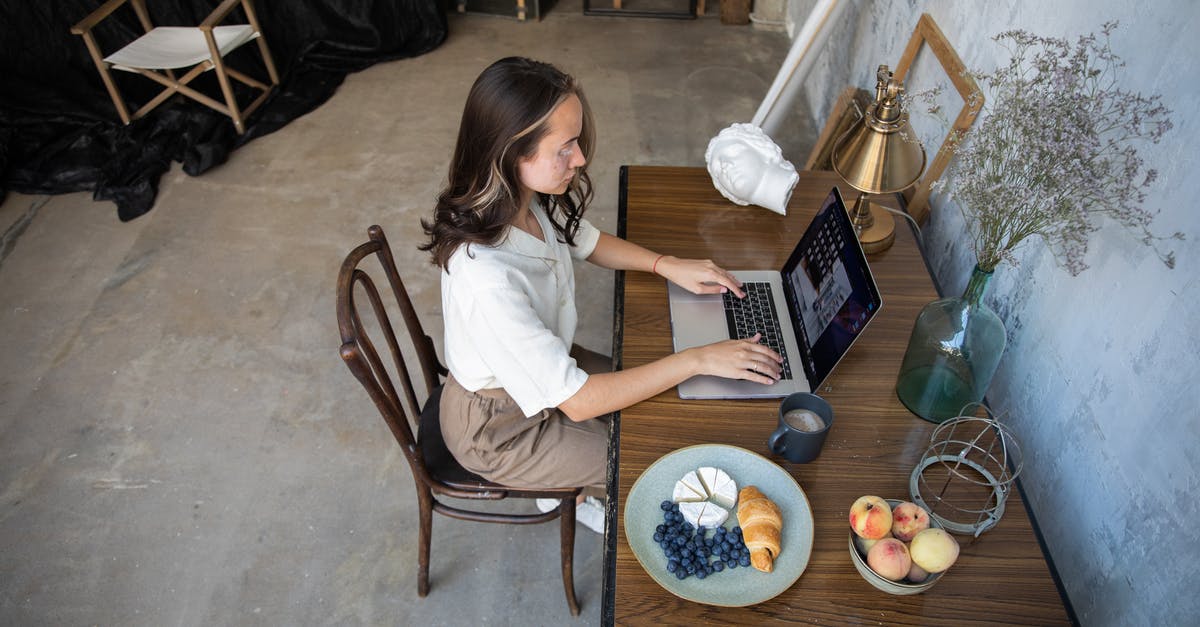 What is this fruit called? - Woman Sitting and Working on a Laptop while Having Lunch 