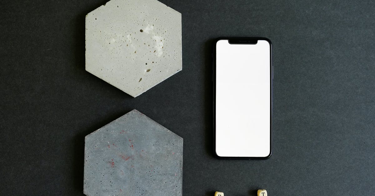 What is this oddly shaped hinged device with indentations? - Hexagon Shaped Stone Beside a Cellphone with White Screen on a Black Surface