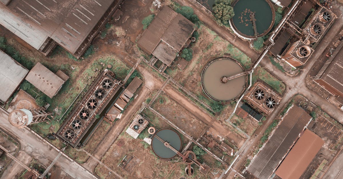 What is used in the production of dubu (Korean tofu)? - Drone view of shabby factory with round settling tanks with mechanical means removing solids in water treatment plant