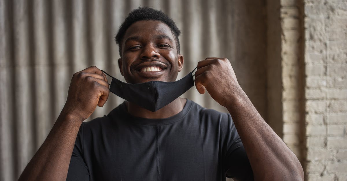 What kind of frosting doesn't need to be refrigerated? - Cheerful black man with fabric mask against ribbed wall