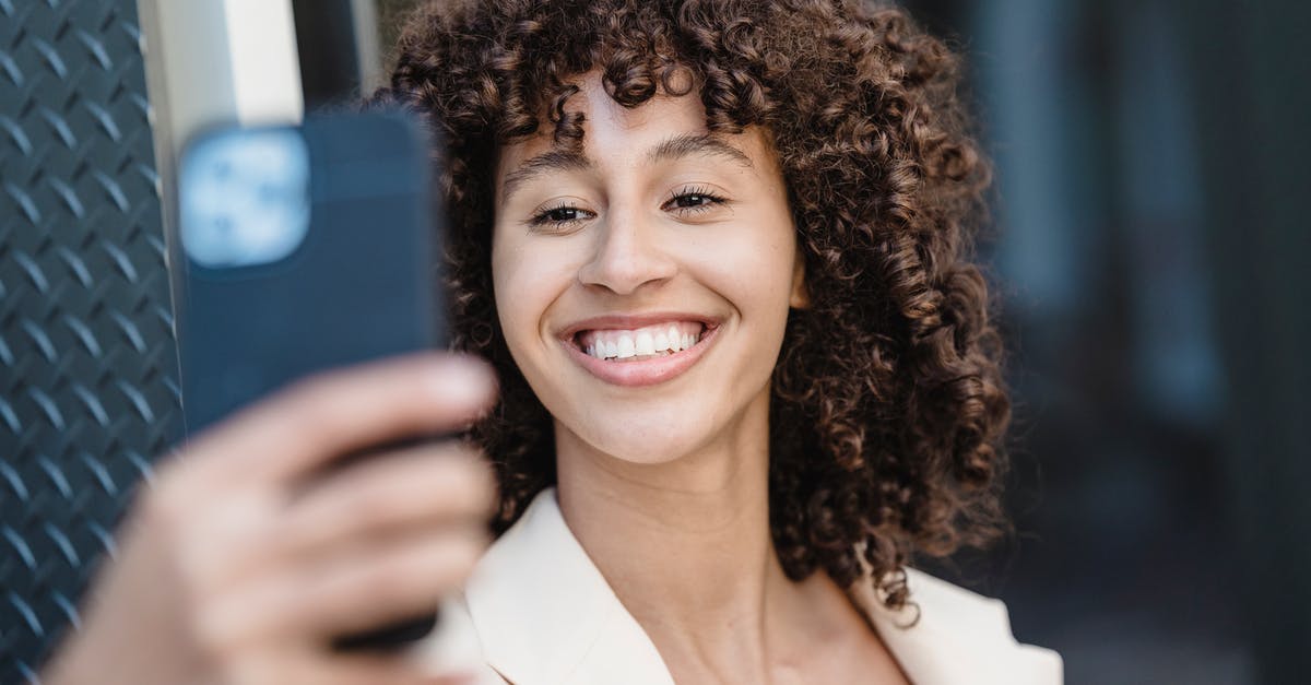 What kind of steak to use for fajitas? - Positive young ethnic female with curly brown hair taking self shot on cellphone in town on blurred background