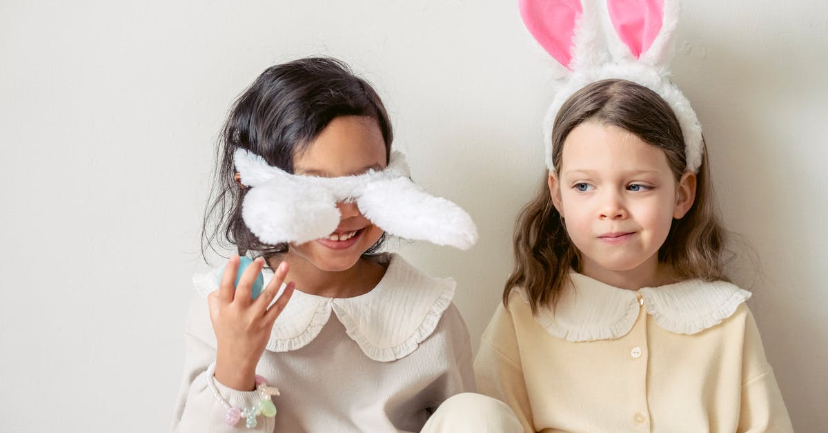 What kind of wok do I have? - Smiling multiethnic girls playing with bunny ears on light background