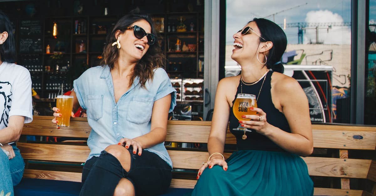 What makes alcohol-free beer sweet? - Two Smiling Women Sitting on Wooden Bench