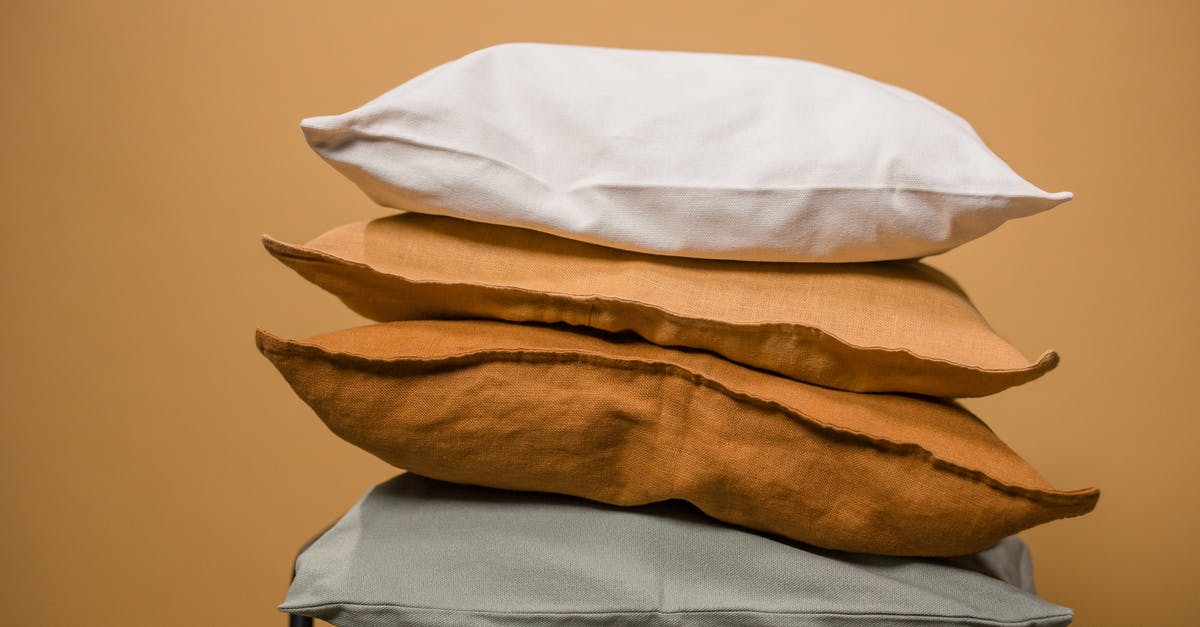 What makes the difference between domed and flat cookies? - Stack of different colorful pillows folded and placed in stack on chair isolated on dark beige background