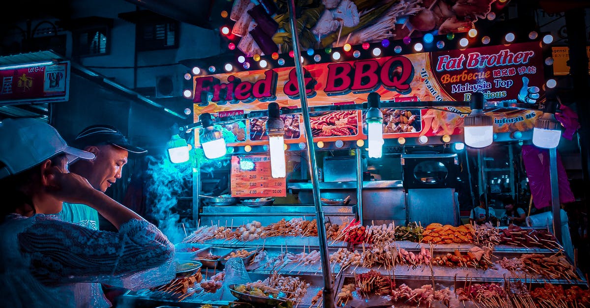 What methods are there of getting fresh local meat & produce? - Customer choosing raw kebab in street stall at night